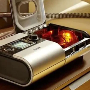 Humidificador H5i sobre a mesa de cabeceira em um quarto com pouca luz.